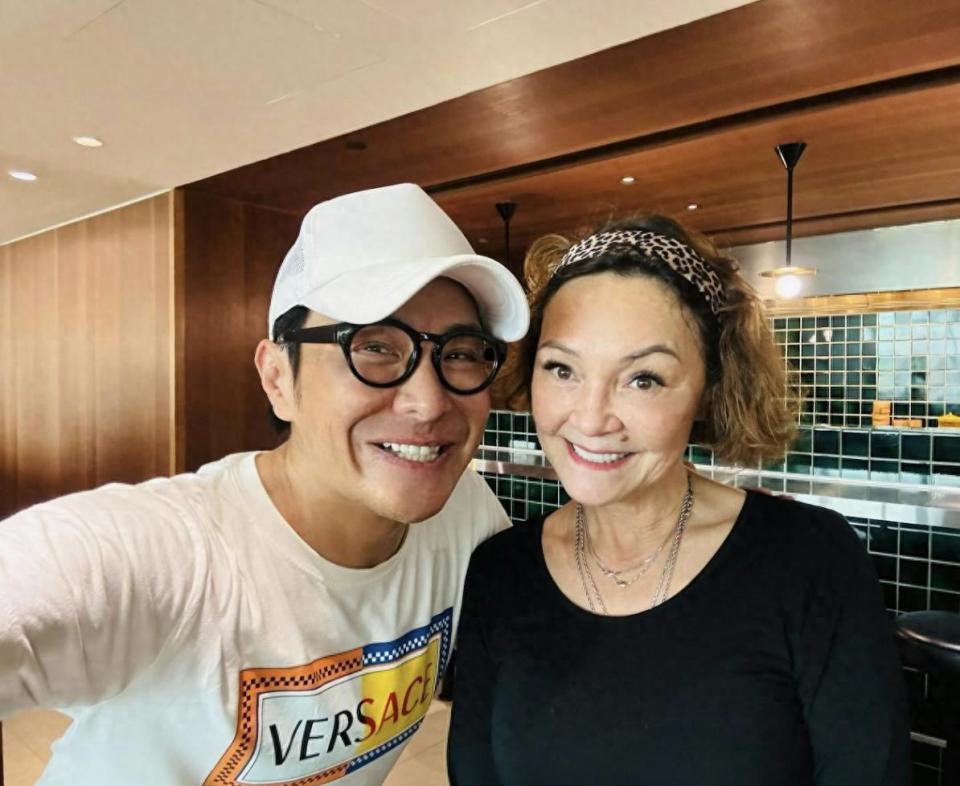 张柏芝母亲戴莎妮罕露脸，在街边茶档喝茶聊天，怀抱爱犬生活惬意